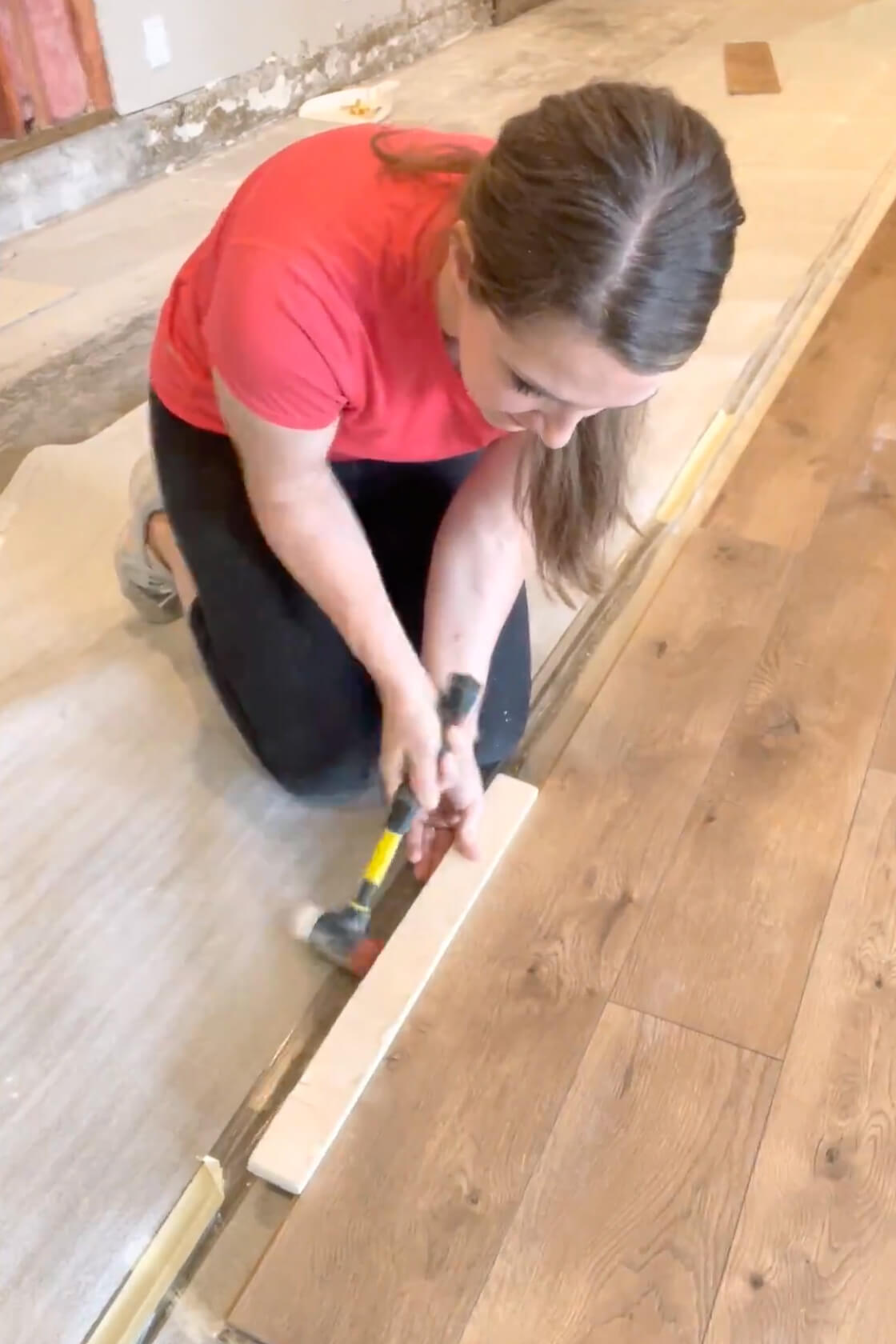 Demonstrating how to lock laminate flooring planks together.